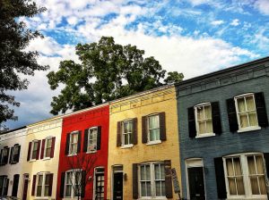 Colorful row houses under a cloudy sky.