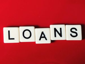 Letter tiles spelling "LOANS" on red background.