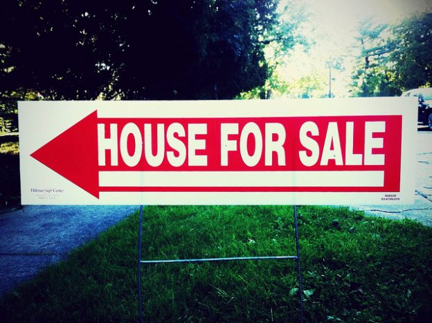 House for sale sign with red arrow.