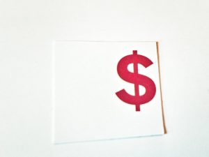 Red dollar sign on white square paper.
