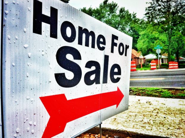Home for sale sign with red arrow.